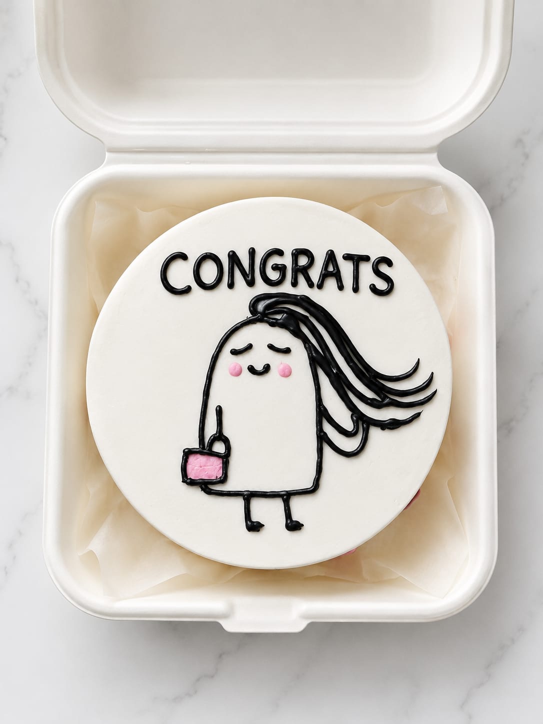 Small white bento cake in a takeout box featuring a cute doodle character and a Congrats message, a mini gift cake in Bahrain.