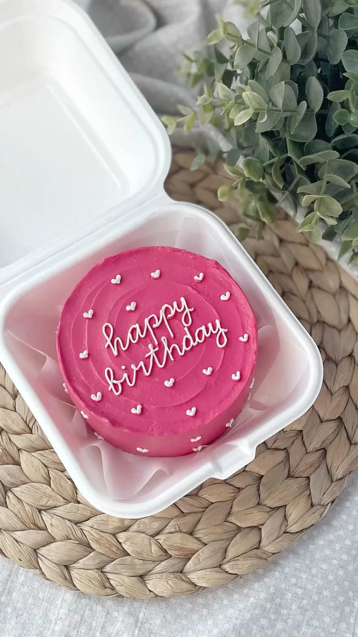 Mini bento cake in vibrant hot pink buttercream with piped white hearts, a bold birthday bento cake in Bahrain.