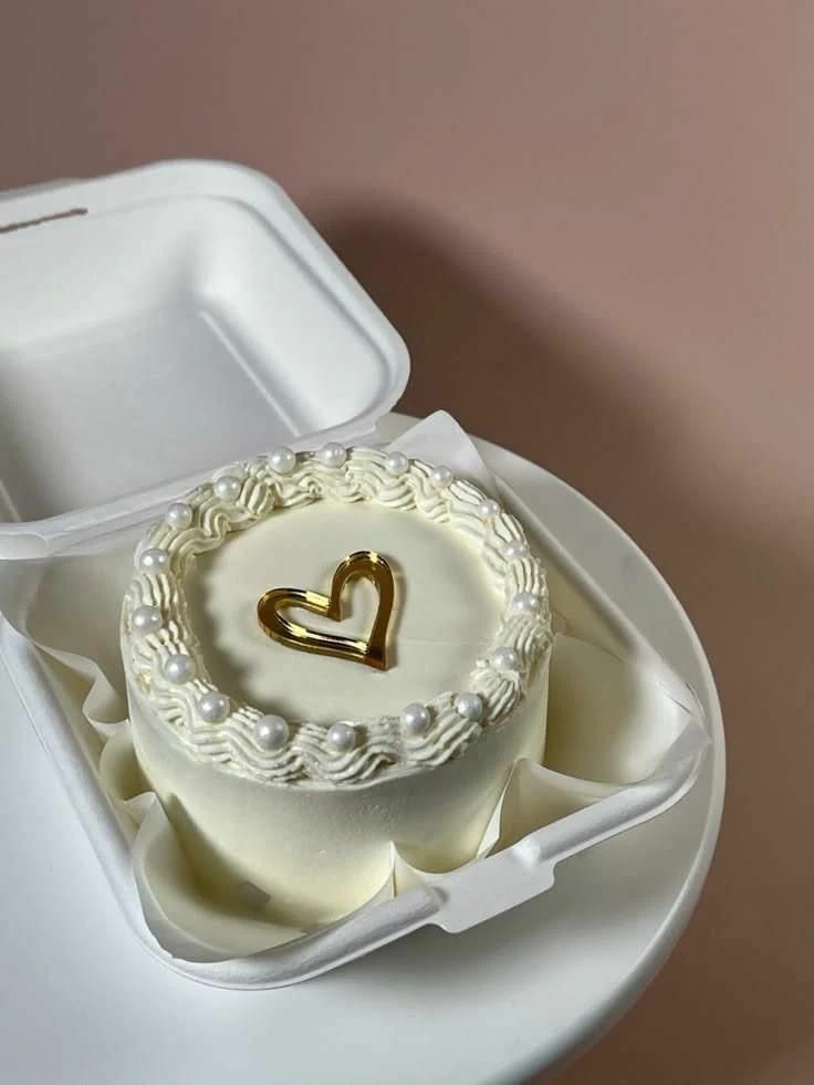 Small round ivory bento cake with a pearl border and gold heart topper, a mini cake gift in Bahrain.