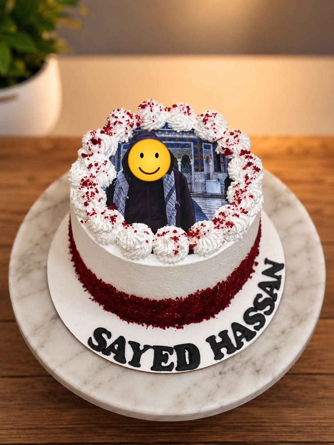 Red velvet crumb cake with whipped cream rosettes framing a personal photo of a young man, customized with the name Sayed Hassan for a Bahrain birthday.
