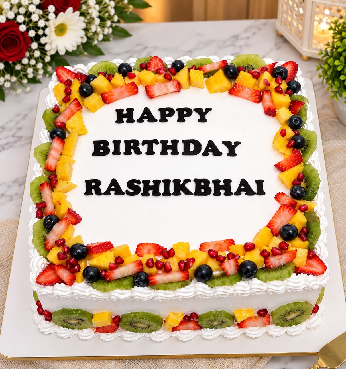 Square whipped cream birthday cake bordered with fresh strawberries, kiwi, mango, blueberries and pomegranate seeds, personalised 'Happy Birthday Rashikbhai' in black fondant letters, in Bahrain.