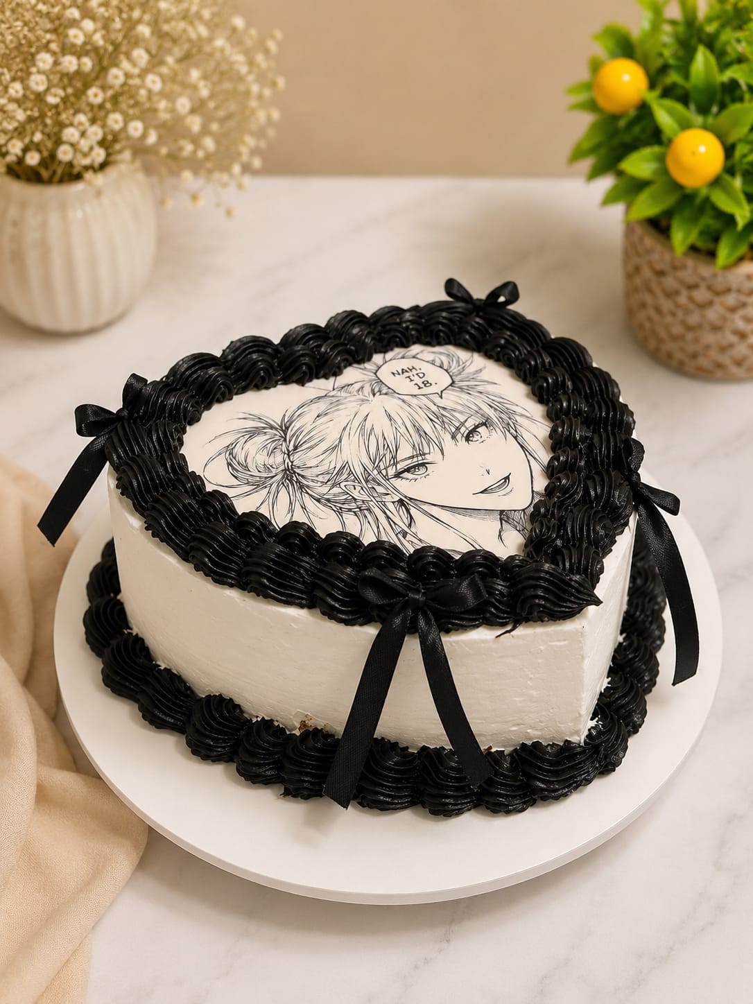 Heart shaped vintage style cake with black piped shell borders, black ribbon bows, and a monochrome anime print topper, made in Bahrain.