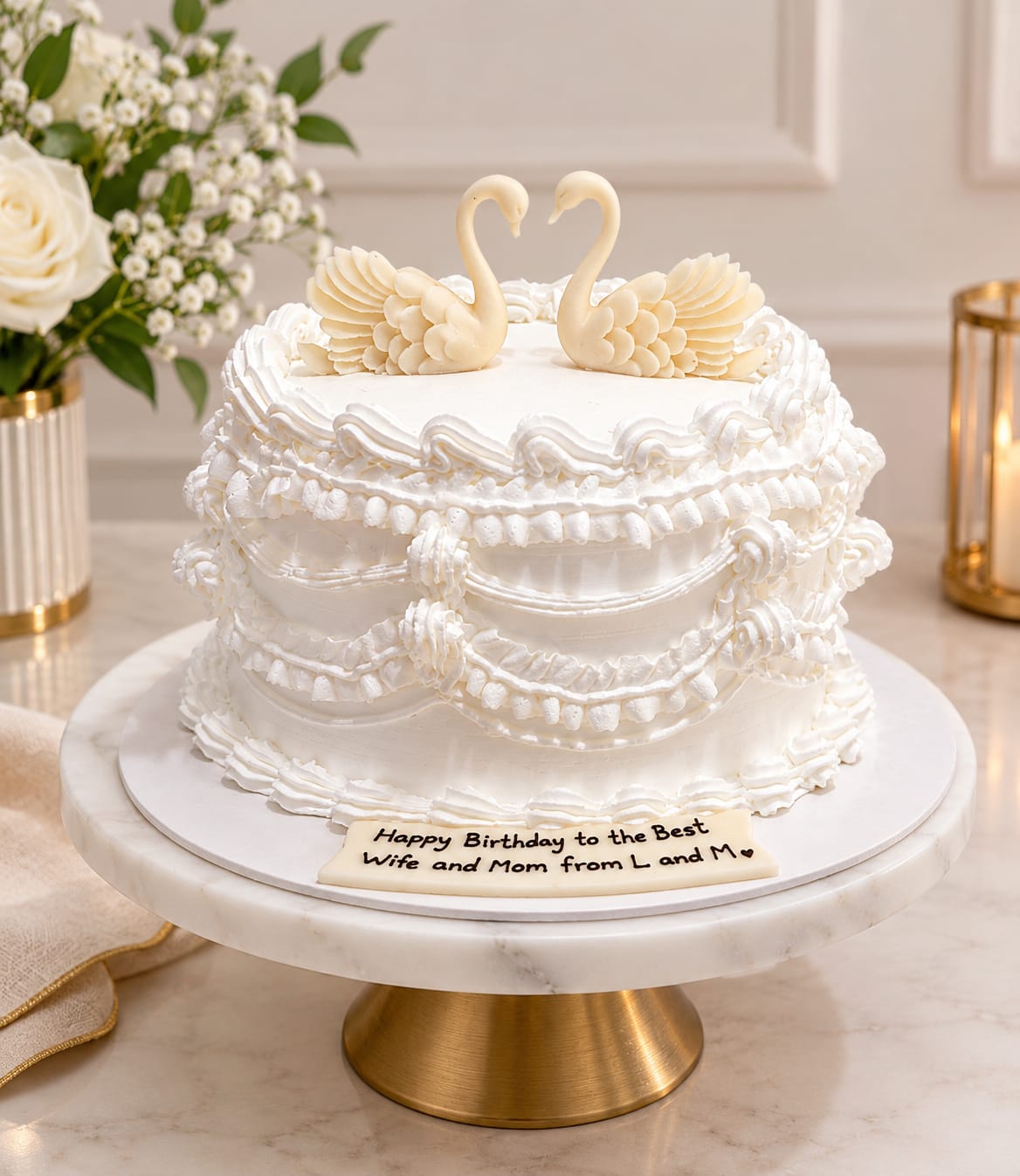 White vintage Lambeth-piped cake topped with two sculpted white chocolate swans forming a heart, made from scratch by CakeCanva in Bahrain.