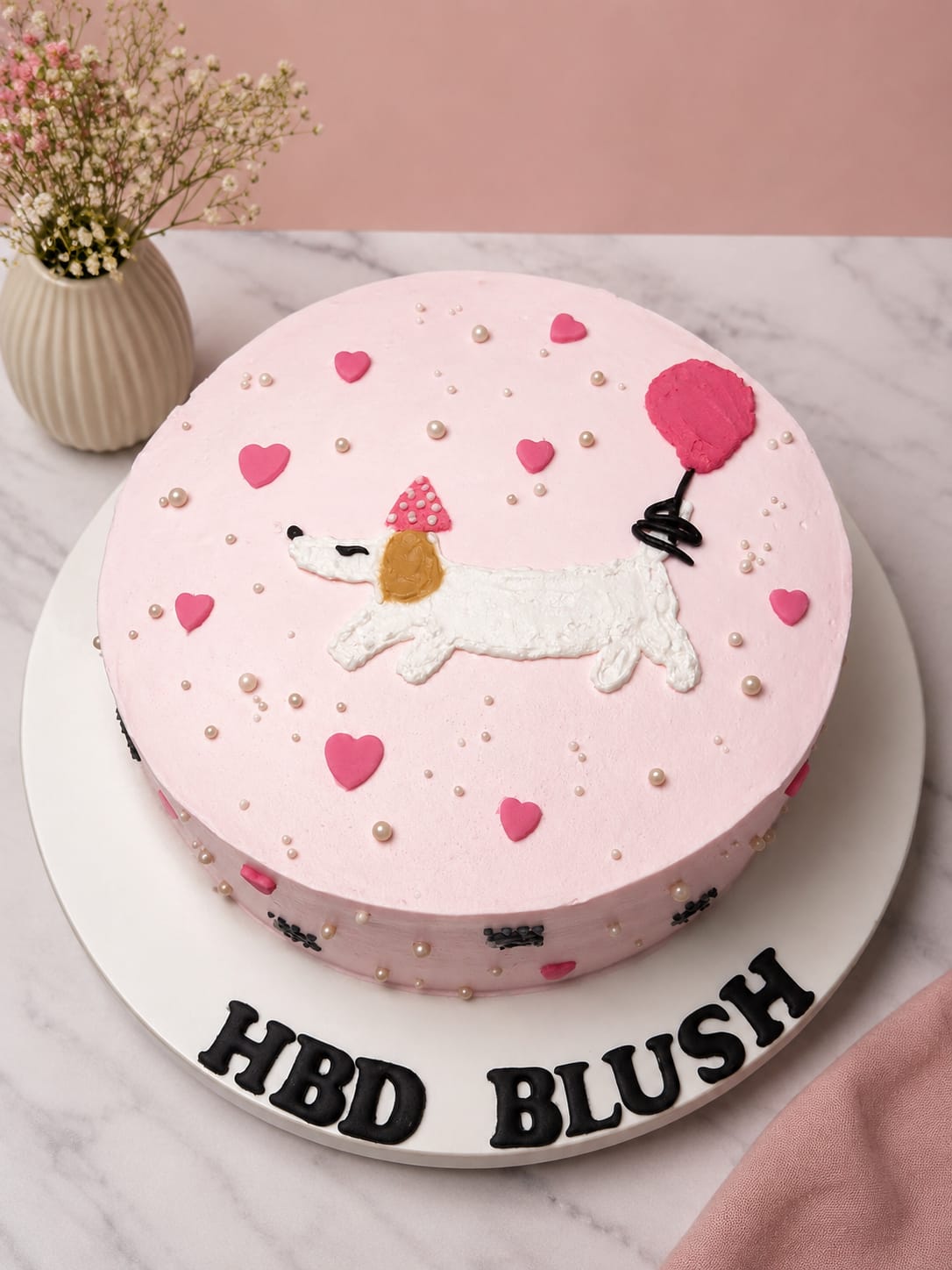 Pink buttercream birthday cake hand-painted with a dachshund puppy in a party hat, hearts and a balloon, personalised 'HBD Blush' by CakeCanva in Bahrain.