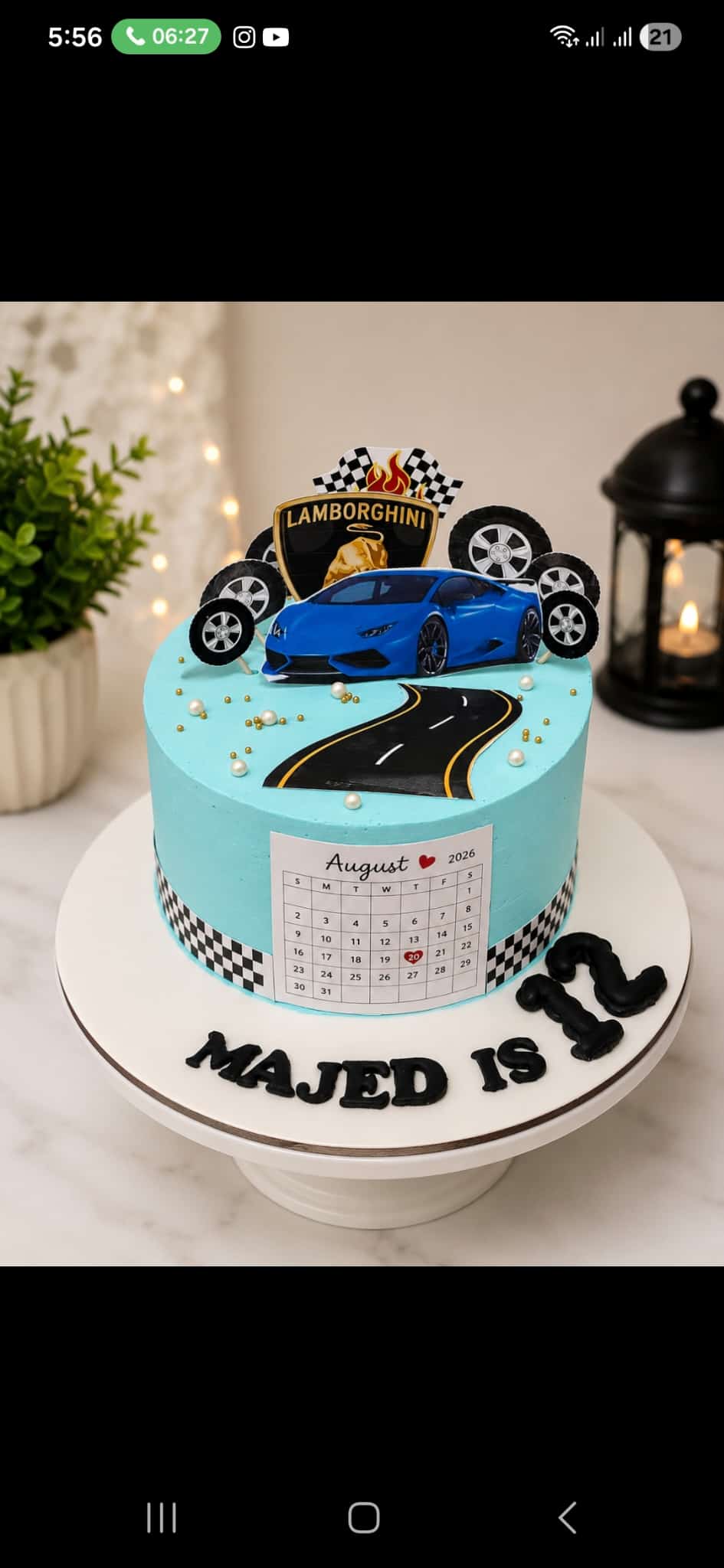 Turquoise buttercream birthday cake with a blue Lamborghini car cutout, checkered flags and a winding road, personalised 'Majed is 12' in Bahrain.
