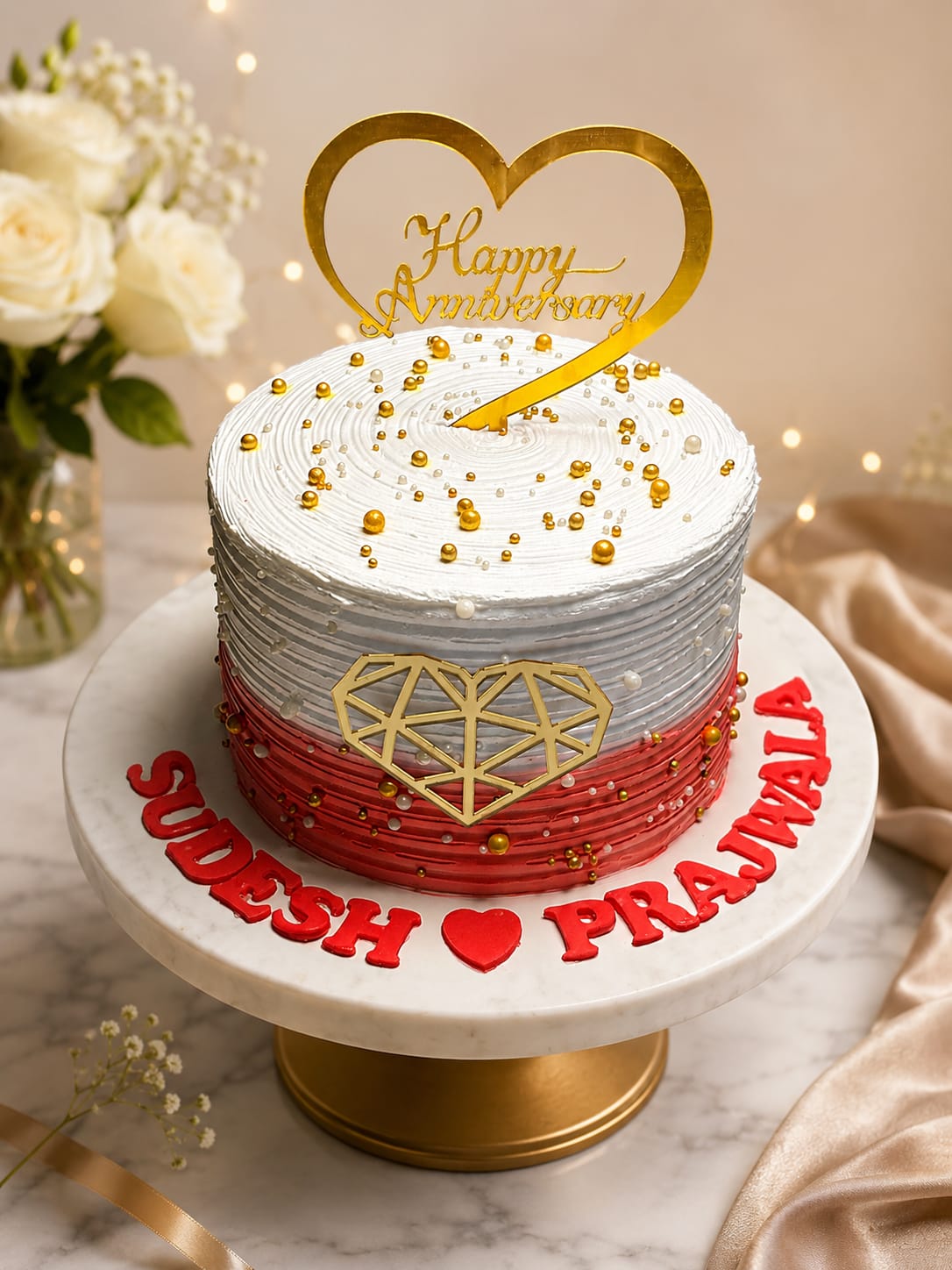 Textured red-to-white ombre buttercream cake with a gold geometric heart, gold pearls and a Happy Anniversary topper, personalized with names for couples celebrating in Bahrain.